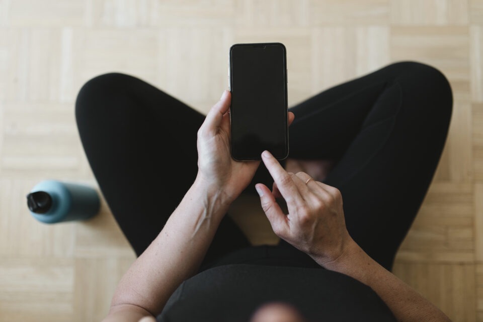 Woman in sportswear using her mobile phone during the coronaviru